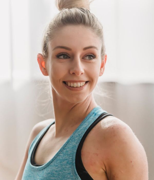 Woman smiling during a light cardio exercise in a bright room.